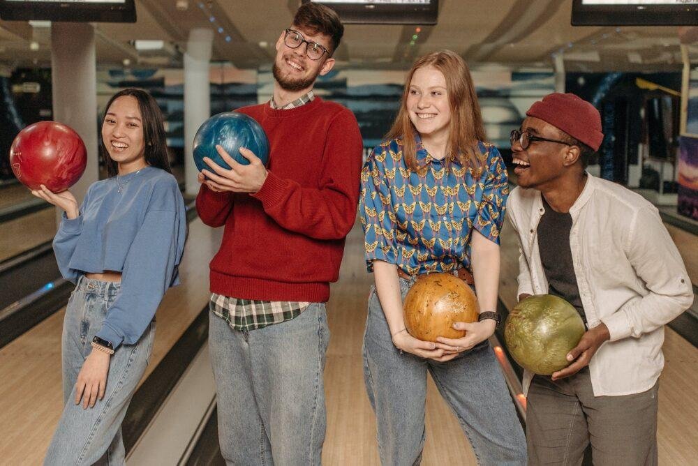 close up shot of a group of friends holding bowling balls